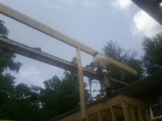 Carpenter setting a ridge beam over a new addition frame — Ice Dam Removal by Roofing Brothers in Grand Terrace