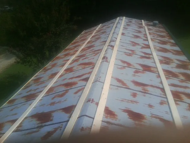 Rusted metal roof panels with new wood purlins before replacement — Storm Damage Roof Repair in Grand Terrace by Roofing Brothers