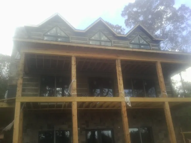 Dormers and porch framing on a large log home under construction — Roof Coating work by our crew in Grand Terrace