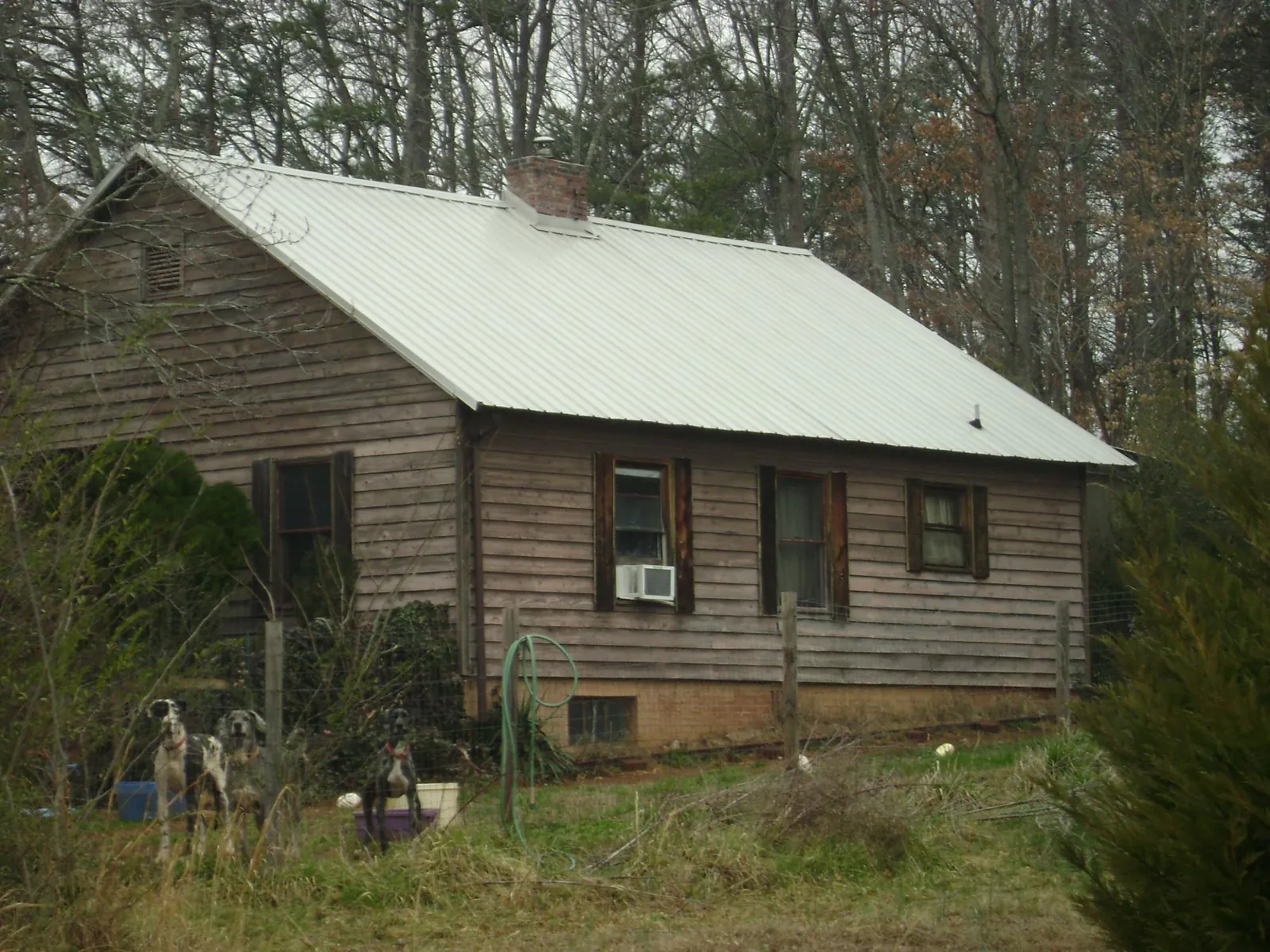 White metal roof on an old wood sided farmhouse, from a Metal Roof Installation job in Grand Terrace